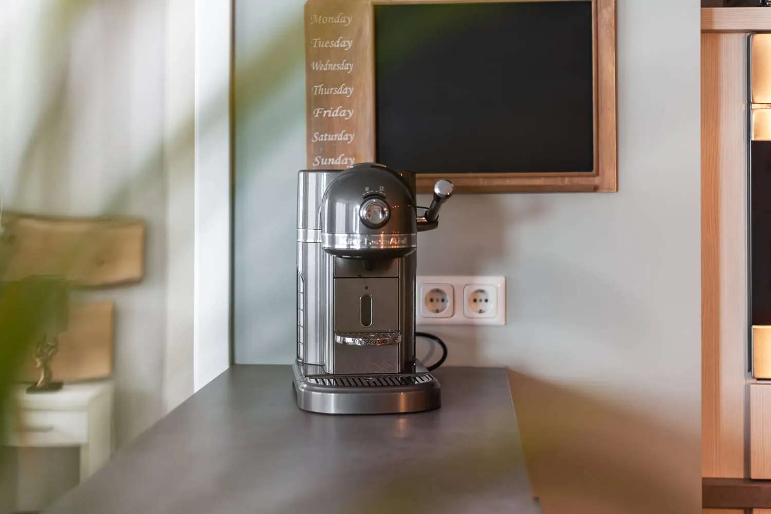 Die Kaffeemaschine auf der Arbeitsplatte, daneben die Tafel mit den Wochentagen