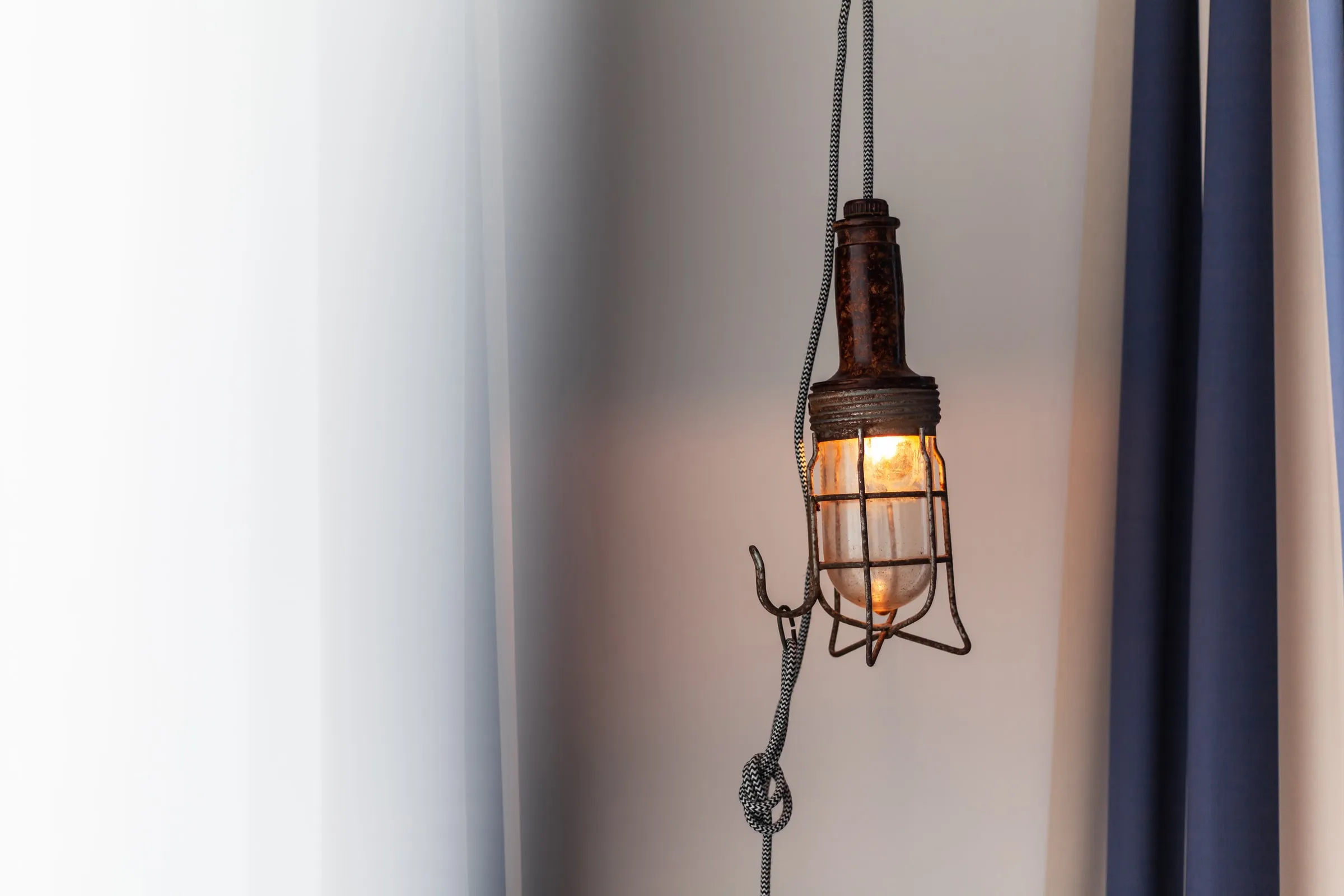 Eine Lampe im Drahtkäfig an der Wand